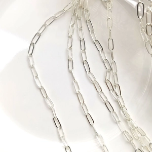 Detail shot of silver rectangular paperclip chain with polished metallic finish