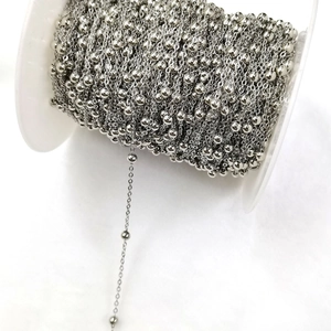 Macro view of silver satellite chain rolls with beads for DIY jewelry making