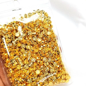 Dettaglio di perline distanziatrici sfaccettate placcate oro 18K in un sacchetto trasparente
