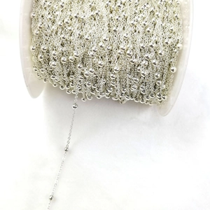 Macro detail of silver 3.5mm bead chain on spool for DIY jewelry necklace making