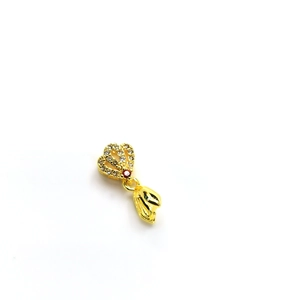 Macro shot of 18k gold-plated pendant clasp with cubic zirconia and red gem accent