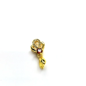 Macro detail of 18k gold plated bail featuring red gemstone and cubic zirconia accents