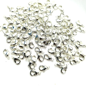 Bulk silver lobster clasps for DIY jewelry making in a pile on a white background