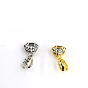 Detail of 18k gold and silver pendants featuring sparkling cubic zirconia in traditional lock shapes