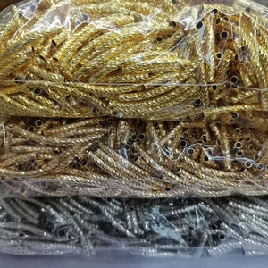 Gros plan de perles tubes courbés torsadés en or 14 carats pour création de bijoux DIY