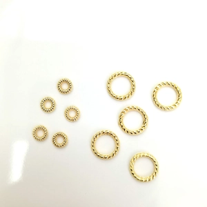 Macro view of 14k gold plated twisted and beaded textured jump rings for DIY jewelry