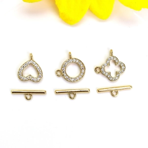 Macro detail of 14K gold plated clover and heart OT toggles with micro-pave zirconia