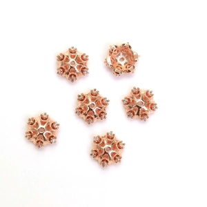 Makroaufnahme von roségoldenen Schneeflocken-Zwischenperlen mit glitzernden Zirkonia-Steinen
