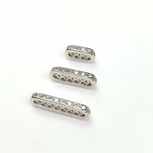 Dettaglio macro di distanziatori ovali in argento con zirconi per gioielli fai da te