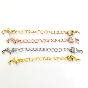 Detail of 14k gold-filled jewelry extension chains with lobster clasps and dolphin charms