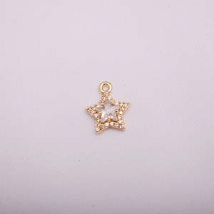 Detailed macro view of a 14K gold star charm with micro-pave cubic zirconia crystals