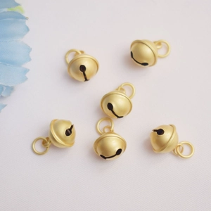 Lot de six grelots mats dorés 14K pour la création de bijoux sur fond blanc épuré