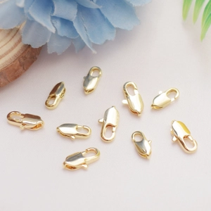 14K gold-plated brass lobster clasps set for DIY jewelry making on pink fabric