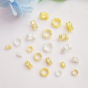 Detailed macro view of 14K gold-plated flower hollow spacer beads and DIY jewelry findings