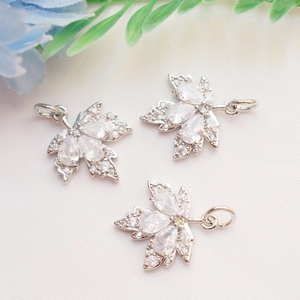 Macro detail of silver maple leaf pendants with shimmering micro-pave cubic zirconia crystals