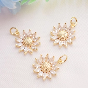 Macro detail of three 14K gold plated sunflower pendants with clear zircon stones