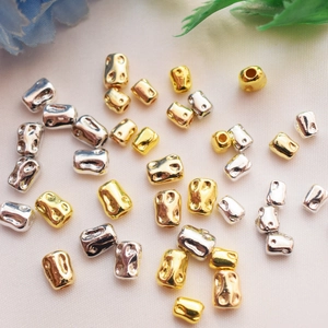 Nahaufnahme von gold- und silbernen Hammerschlag-Abstandshaltern für DIY-Schmuck