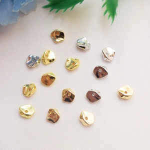 Nahaufnahme unregelmäßiger 14k vergoldeter Abstandsperlen in Gold, Silber und Bronze für DIY
