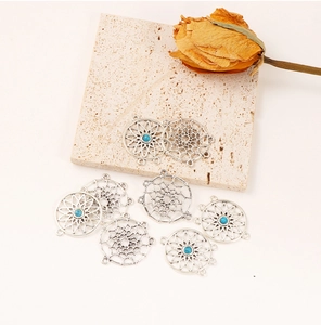 Detail of retro silver dreamcatcher pendants with blue beads and sunflower charms for DIY