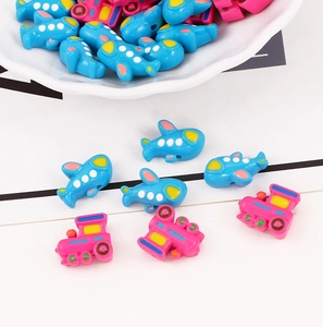 Macro view of colorful acrylic airplane and train beads for DIY jewelry making and crafts