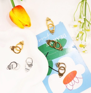 Detail of alloy handcuff pendants engraved with Freedom for DIY jewelry making