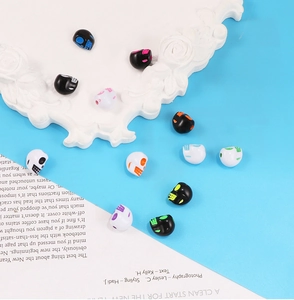 Vue détaillée de perles tête de mort en acrylique coloré pour bijoux DIY sur un plateau