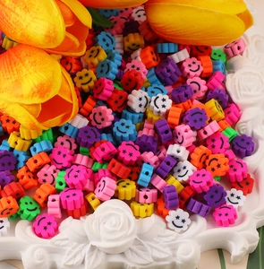 Vue macro de perles de fleurs souriantes colorées en pâte polymère dans un plateau