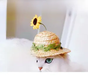 Close-up of woven straw pet hat featuring a bright yellow sunflower and green leaves