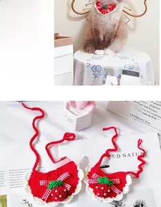 Detail view of handmade red knit pet collar with strawberry ornament and white lace edge