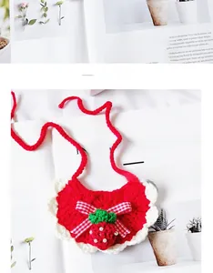 Detailed view of hand-knitted pet bib with strawberry pendant and red checkered bow tie