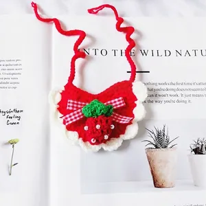 Handmade knitted strawberry pet bib with red bow and white lace trim for cats and dogs