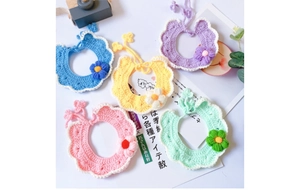 Detail of five handmade knit pet collars with white scalloped edges and floral accents