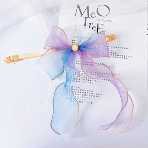 Close-up of a gradient organza pet bow collar with a pearl center and a safety buckle