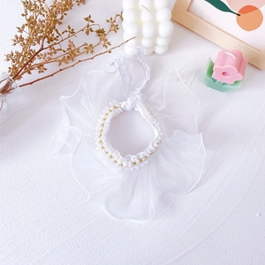Detail of white lace pet collar with organza ruffles, faux pearls and gold beads