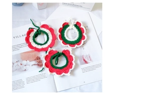 Detailed view of handmade knitted Christmas pet collars in festive red and green patterns