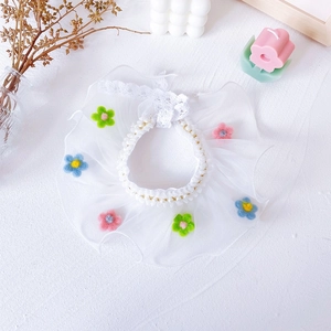 Detail of white lace pet collar with pastel felt flowers and pearl bead trim