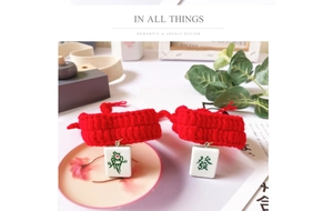 Macro detail of red knitted pet collar with traditional Mahjong lucky charms