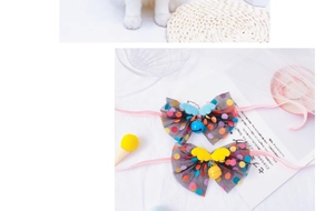 Detail of pet bow collar with colorful fairy wings and bell on a silk ribbon