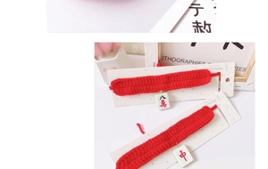 Close-up of red knitted pet collar featuring traditional Chinese Mahjong tile pendants