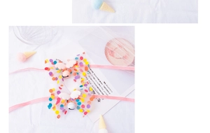 Close-up of pet collar with rainbow polka dot mesh, fairy wings and a pink bell