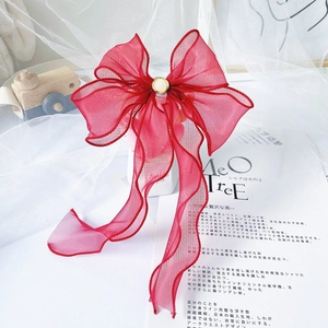 Detail view of red organza bow collar with a pearl center for cats and dogs
