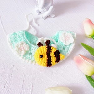 Detail of mint green knitted pet collar with handmade bee and white flower ornaments