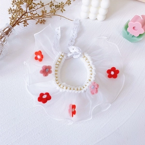 Detail of pet lace collar with white pearls and colorful felt flowers on chiffon lace