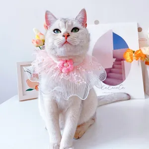 Close-up of pink lace pet collar with a handmade floral pearl on a white cat