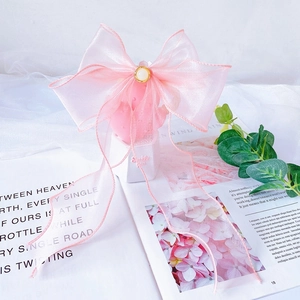 Detailed view of pink organza bow collar with pearl center for cats and dogs