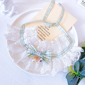 Close-up of pet lace collar featuring a blue checkered bow, pearl, and silver bell