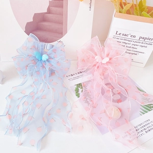 Detail of pink and blue bow cat harnesses featuring peach prints and chiffon streamers
