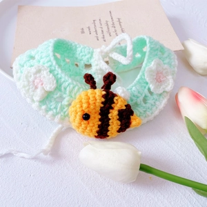 Handmade knitted pet collar with bee charm and flowers in soft green yarn
