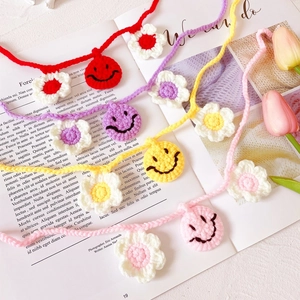 Knitted flower and smiley face pet collars in red, purple, yellow, and pink colors