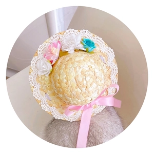 Detail of pet straw hat with lace edge and colorful flowers for cats and dogs